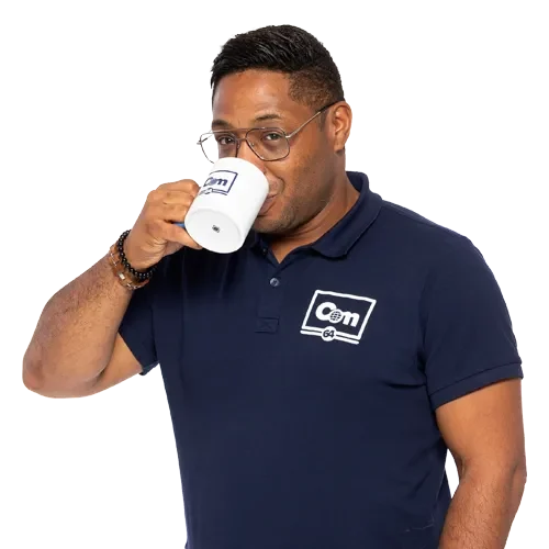 Photo de Cédric Dintimille, buvant un café dans un mug COM 64, habillé avec un polo COM 64.